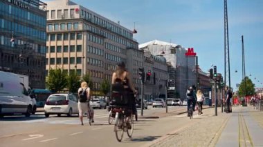 Kopenhag, Danimarka - 24 Temmuz 2024: İnsanlar şehir merkezinin sokaklarında yürüyorlar ve bisiklete biniyorlar