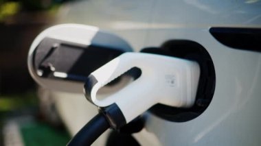 Beyaz elektrikli arabanın şarj olduğu yeri kapat.