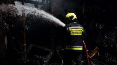 İtfaiyeci yangını söndürmeye çalışıyor.