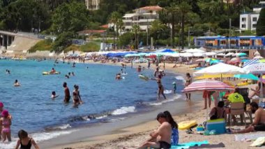 Vallauris, Fransa - 14 Temmuz 2024: İnsanlar denizde yüzüyor ve Golfe-Juan kasabasında plajda dinleniyorlar