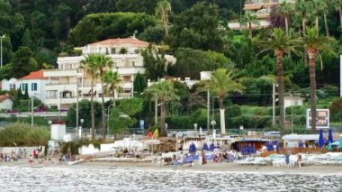 Cannes, Fransa - 15 Temmuz 2024: İnsanlar sahilde yüzüyor ve dinleniyor