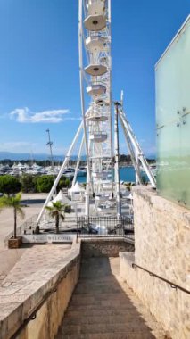 Antibes, Fransa 'da dönen beyaz dönme dolabın yan görüntüsü. Dikey