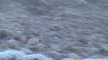 Fransa 'nın Antibes kentindeki taştan bir plajda dalgalar kıyıya vuruyor.