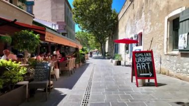 Antibes, Fransa - 20 Temmuz 2024: İnsanlar şehrin sokaklarındaki açık kafelerde oturuyorlar