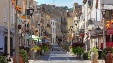 Vallauris, Fransa - 14 Temmuz 2024: Komünde dekore edilmiş bir sokakta arabalar hareket ediyor