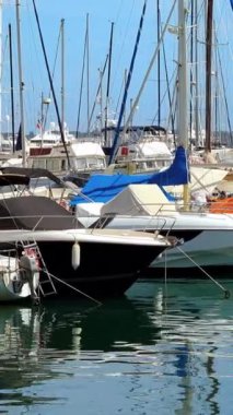 Güneşli bir günde Port de Golfe-Juan 'a yanaşan tekneler. Dikey