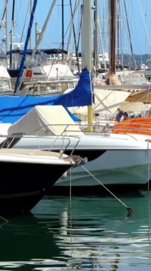 Güneşli bir günde Port de Golfe-Juan 'a yanaşan tekneler. Dikey