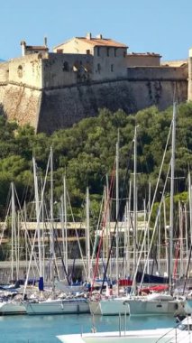Arka planda Fort Carre ile Vauban Antibes Limanı 'na yanaşan tekneler. Dikey, Antibes, Fransa