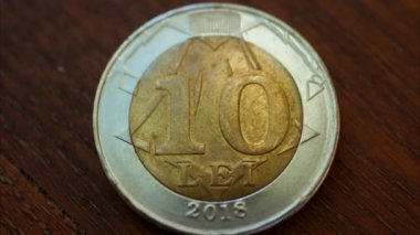 10 lei mdl 'lik bozuk parayı ahşap bir yüzeye yakın tut.