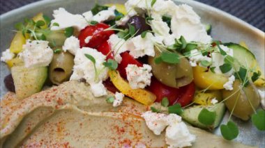 Terasta masasında humus olan Yunan salatasını kapat.