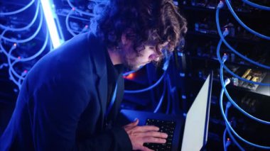 Bir veri merkezindeki bir bilgisayarda sunucuları ve programları analiz eden adam