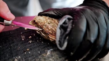 Restoranda çiğ istiridye açan bir garsona yaklaş.