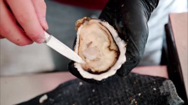 Restoranda çiğ istiridye kesen bir garsona yaklaş.