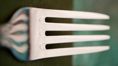 Yeşil bir peçeteye çatal yakın. Dikey