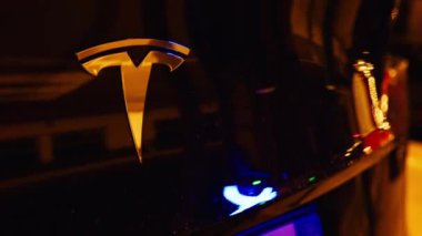 Aargau, İsviçre - 14 Eylül 2024: Geceleri siyah bir Tesla arabasının logosunu kapatın