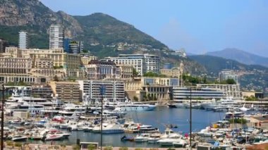 Monaco Marina 'ya kenetlenmiş teknelerin görüntüsü ve arka planda şehrin silüeti.
