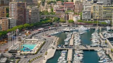 Monaco Marina 'ya kenetlenmiş teknelerin görüntüsü ve arka planda şehrin silüeti.
