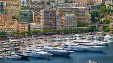 Monaco Marina 'ya kenetlenmiş teknelerin görüntüsü ve arka planda şehrin silüeti.