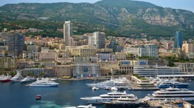 Monaco Marina 'ya kenetlenmiş teknelerin görüntüsü ve arka planda şehrin silüeti.