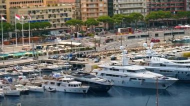 Monaco Marina 'ya kenetlenmiş teknelerin görüntüsü ve arka planda şehrin silüeti.