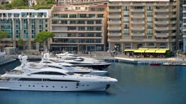 Monaco Marina 'ya kenetlenmiş teknelerin görüntüsü ve arka planda şehrin silüeti.