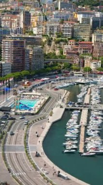 Arka planda şehrin silueti olan Monaco Marina 'daki teknelerin görüntüsü. Dikey