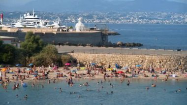 Antibes, Fransa - 20 Temmuz 2024: İnsanlar denizde yüzüyor ve plajda dinleniyorlar