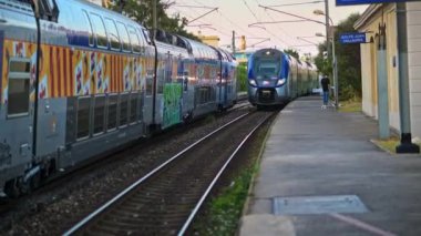 Antibes, Fransa - 20 Temmuz 2024: İstasyondan geçen iki gri, uzun tren