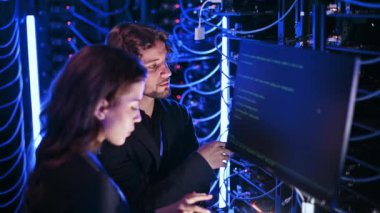 Sunucu odasında programlanan bir erkek ve bir kadın.