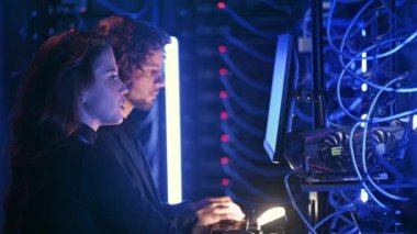 Sunucu odasında veri analiz eden bir erkek ve bir kadın.