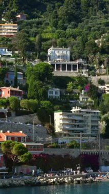 Arka planda Fransa 'nın Villefranche sur Mer kentindeki binaların olduğu sahili görüyoruz. Dikey