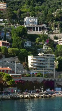 Arka planda Fransa 'nın Villefranche sur Mer kentindeki binaların olduğu sahili görüyoruz. Dikey
