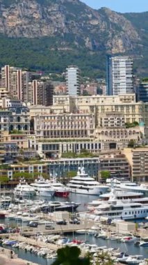 Arka planda şehrin silueti olan Monaco Marina 'daki teknelerin görüntüsü. Dikey