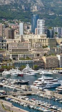 Arka planda şehrin silueti olan Monaco Marina 'daki teknelerin görüntüsü. Dikey