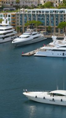Arka planda şehrin silueti olan Monaco Marina 'daki teknelerin görüntüsü. Dikey