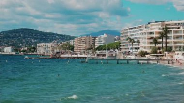 İnsanlar denizde yüzüyor ve Antibes, Fransa 'da plajda dinleniyorlar.