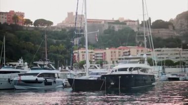 Monaco Marina 'ya kenetlenmiş teknelerin görüntüsü ve arka planda şehrin silüeti.