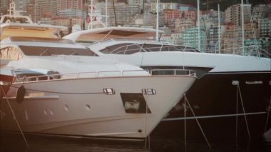Monaco Marina 'ya kenetlenmiş teknelerin görüntüsü ve arka planda şehrin silüeti.