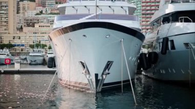 Monaco Marina 'ya kenetlenmiş teknelerin görüntüsü ve arka planda şehrin silüeti.