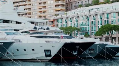 Monaco Marina 'ya kenetlenmiş teknelerin görüntüsü ve arka planda şehrin silüeti.