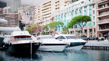 Monaco Marina 'ya kenetlenmiş teknelerin görüntüsü ve arka planda şehrin silüeti.