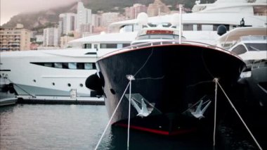 Monaco Marina 'ya kenetlenmiş teknelerin görüntüsü ve arka planda şehrin silüeti.