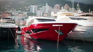Monaco Marina 'ya kenetlenmiş teknelerin görüntüsü ve arka planda şehrin silüeti.