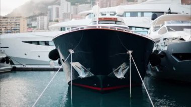 Monaco Marina 'ya kenetlenmiş teknelerin görüntüsü ve arka planda şehrin silüeti.