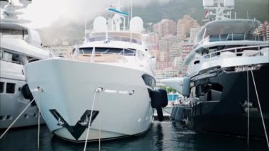 Monaco Marina 'ya kenetlenmiş teknelerin görüntüsü ve arka planda şehrin silüeti.