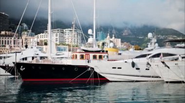 Monaco Marina 'ya kenetlenmiş teknelerin görüntüsü ve arka planda şehrin silüeti.
