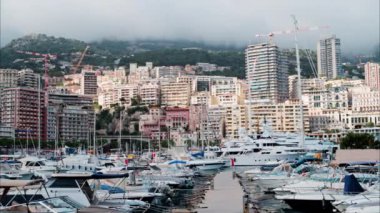 Monaco Marina 'ya kenetlenmiş teknelerin görüntüsü ve arka planda şehrin silüeti.