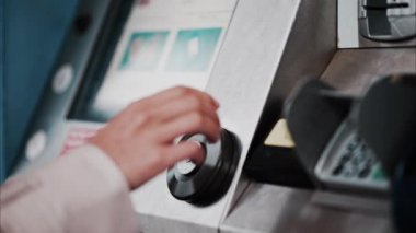 Bilet makinesinden tren bileti alan bir kadına yaklaş.