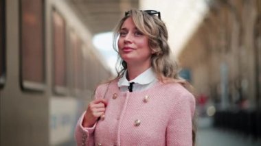 Pembe ceketli bir kadın Fransa 'daki Nice tren istasyonunda yürüyor.