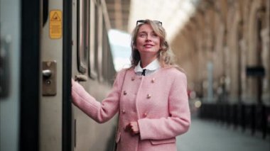 Pembe ceketli bir kadın Fransa 'daki Nice tren istasyonunda yürüyor.